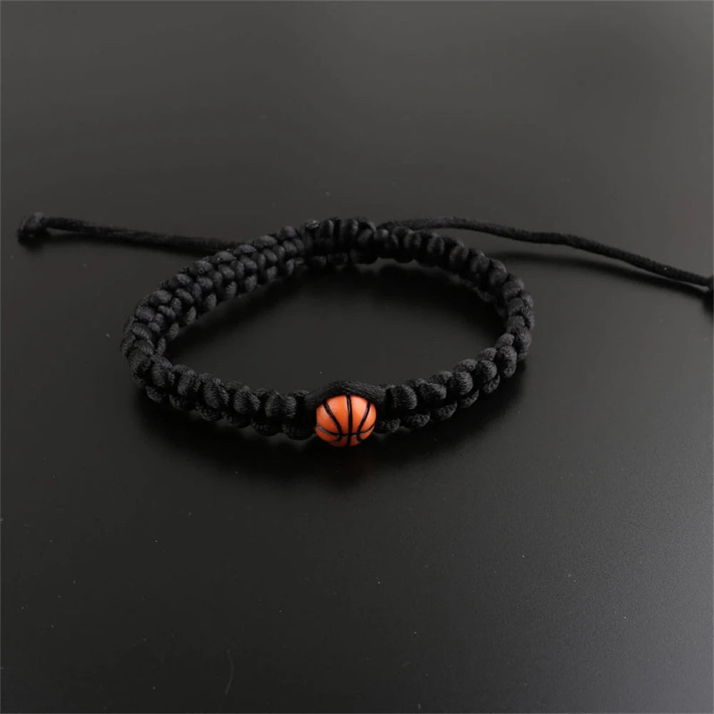 Paracord bracelet with a central basketball bead, available in black and white, perfect for sports fans and athletes seeking a stylish accessory.