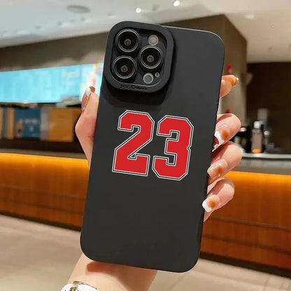 Premium black iPhone case featuring the iconic number 23 in bold red and white outline, perfect for basketball enthusiasts and fans of legendary players. The sleek matte finish provides a firm grip, while the precise camera cutout maintains full functionality. Ideal for protecting your smartphone while showcasing your sports passion with a stylish and durable design.