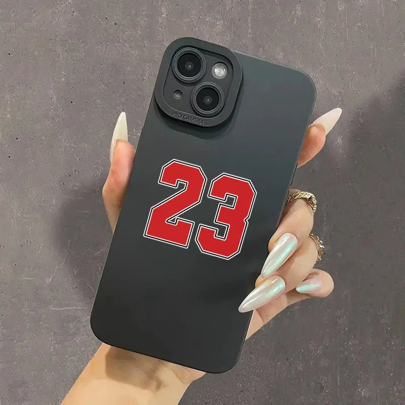 Premium black iPhone case featuring the iconic number 23 in bold red and white outline, perfect for basketball enthusiasts and fans of legendary players. The sleek matte finish provides a firm grip, while the precise camera cutout maintains full functionality. Ideal for protecting your smartphone while showcasing your sports passion with a stylish and durable design.