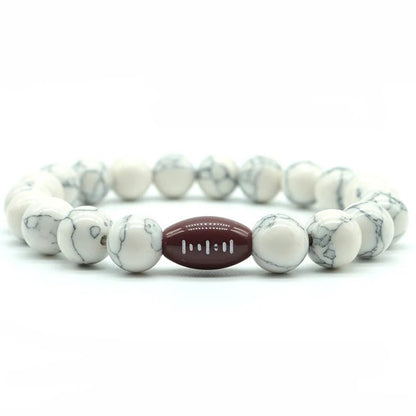 white beaded bracelet featuring a central football bead, perfect for sports fans and athletes looking for a stylish accessory.